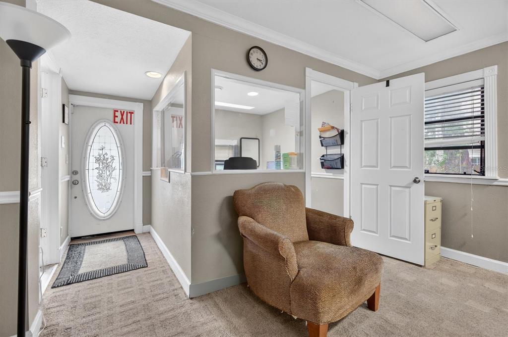 A waiting room features a brown armchair, a reception window, and an exit door — 813 N FERN CREEK AVENUE, ORLANDO, FL