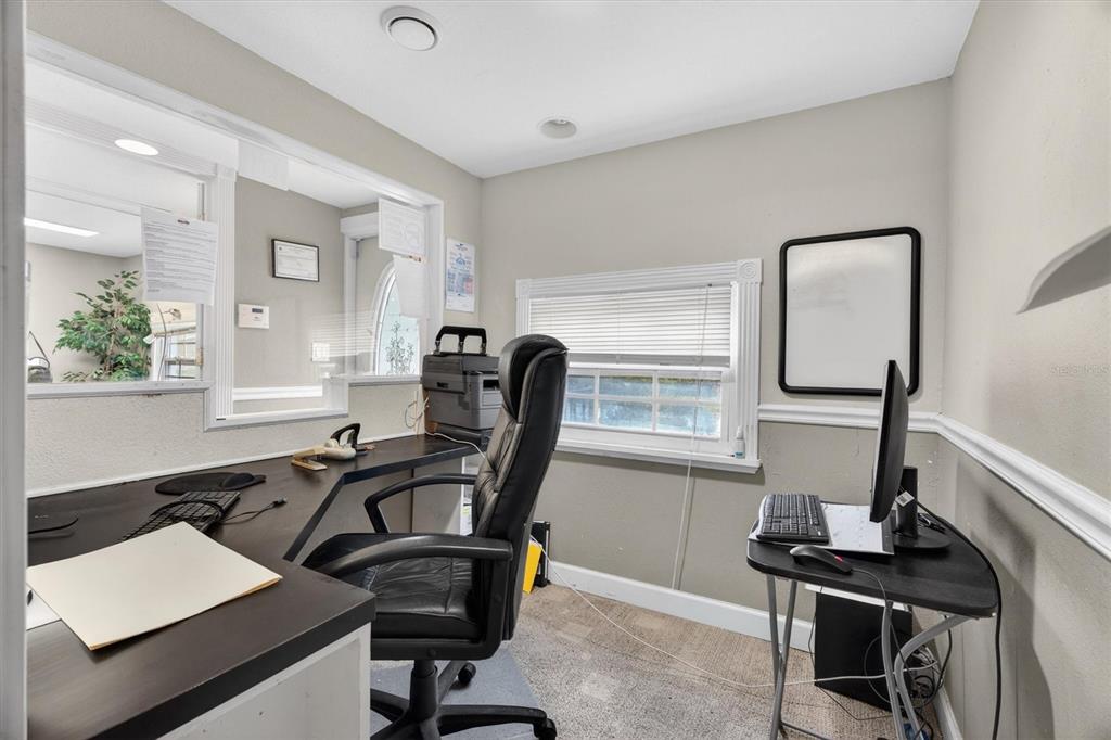 An office space features a dark L-shaped desk, a black chair, and a computer workstation — 813 N FERN CREEK AVENUE, ORLANDO, FL