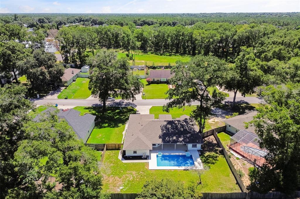 An aerial view of a suburban house with a backyard swimming pool and surrounding trees — 3690 SE 56TH TERRACE, OCALA, FL