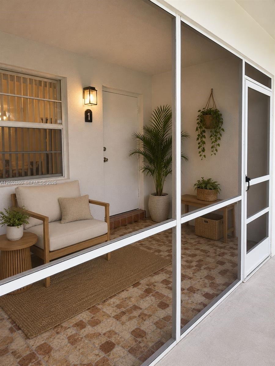 A screened-in porch features tiled flooring, a wooden chair, a bench, and potted plants — 705 NE 2nd St # 11, Hallandale Beach FL 33009, HALLANDALE BEACH, FL