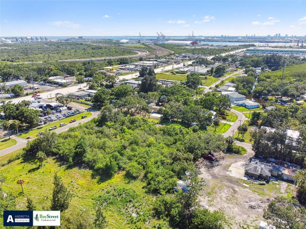 An aerial view shows a wooded lot with nearby residential streets and industrial port facilities — 4713 EL CAMINO BLANCO BOULEVARD, TAMPA, FL