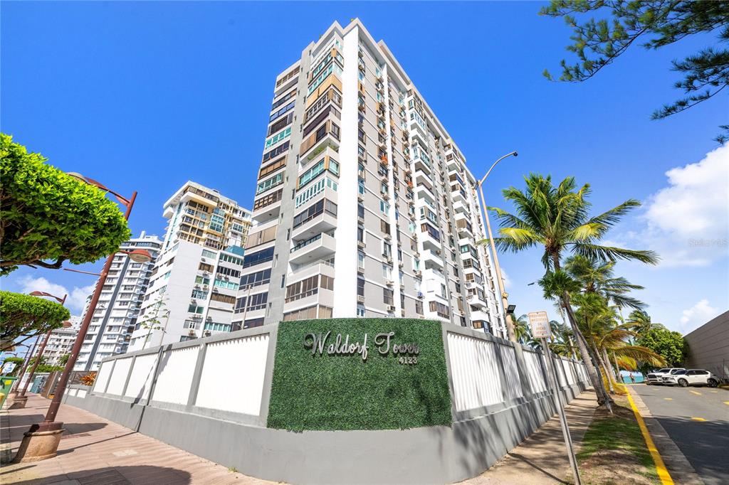 A low-angle exterior view of the Waldorf Tower apartment building under a clear blue sky — 4123 ISLA VERDE AVE, WALDORF TOWER UNIT PH-4, CAROLINA, PR