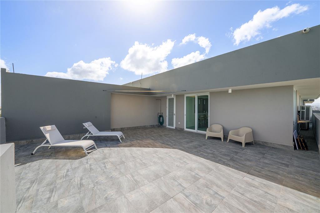 A spacious rooftop terrace features gray tile flooring, two lounge chairs, and two patio chairs — 4123 ISLA VERDE AVE, WALDORF TOWER UNIT PH-4, CAROLINA, PR