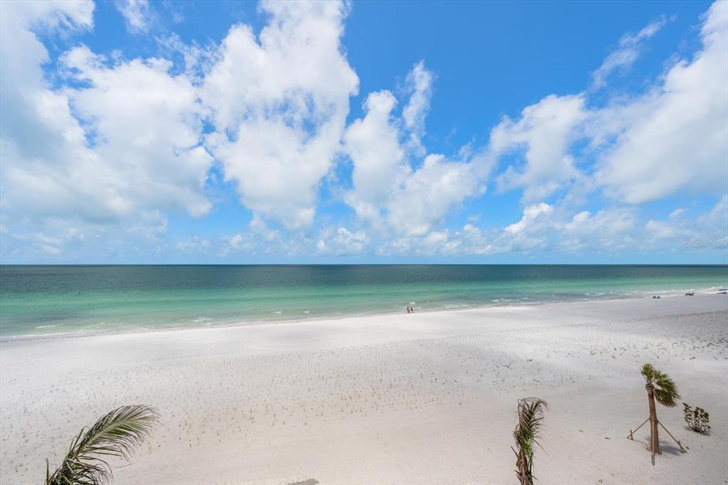 A view of a white sand beach and the ocean under a cloudy blue sky — 1660 GULF BOULEVARD UNIT 403, CLEARWATER BEACH, FL