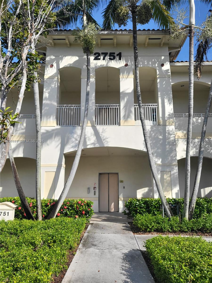 A two-story building exterior features a central entrance, balconies, and palm trees in front — 2751 Executive Park Dr # 202, Weston FL 33331, WESTON, FL