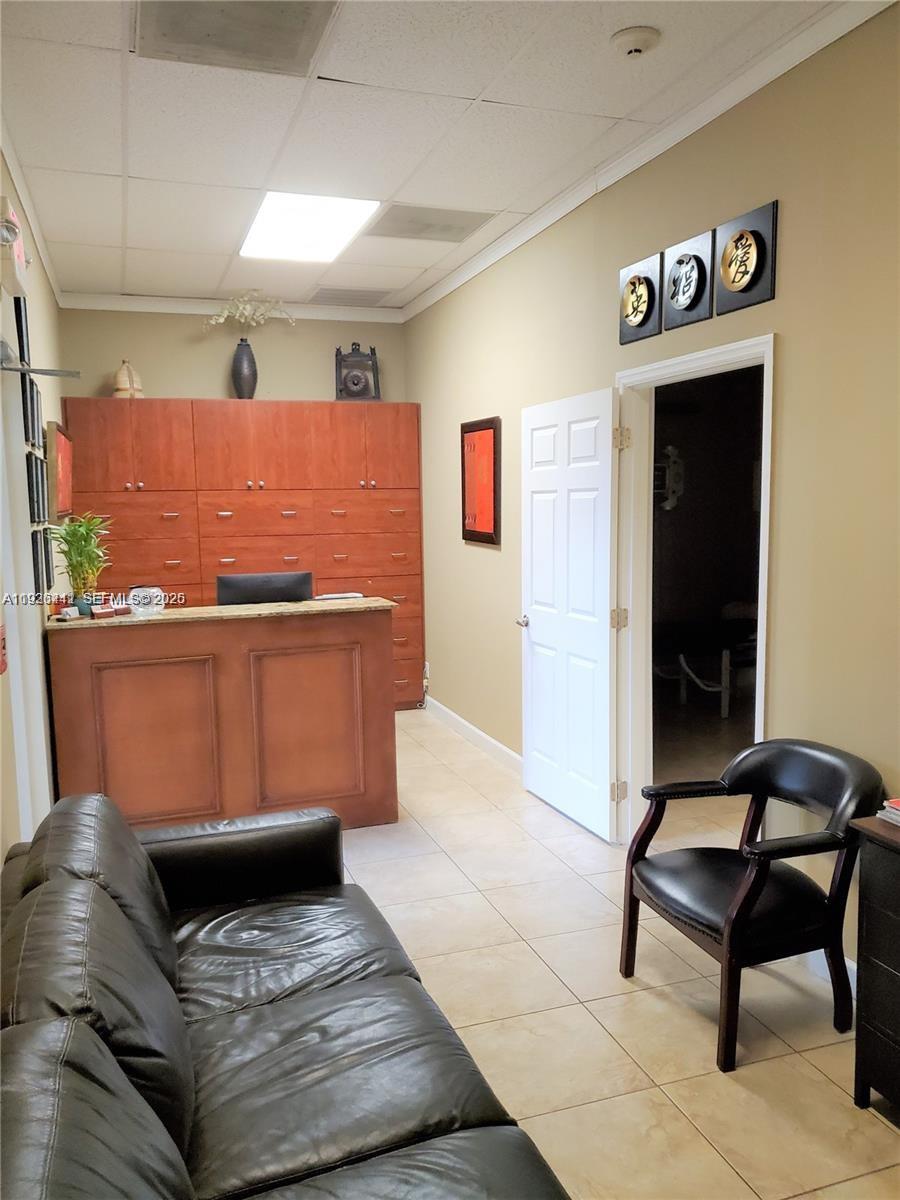 A waiting room features a reception desk, wood cabinetry, a leather sofa, and tile flooring — 2751 Executive Park Dr # 202, Weston FL 33331, WESTON, FL