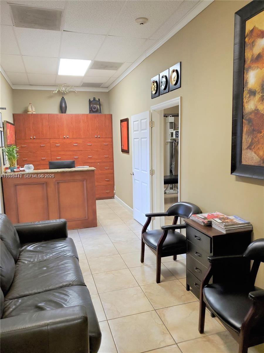 A waiting room features a reception desk, leather seating, tiled floors, and wall art — 2751 Executive Park Dr # 202, Weston FL 33331, WESTON, FL