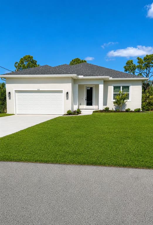 A single-story house with a white exterior, a two-car garage, and a green lawn — 122 NAOMI PL, ROTONDA WEST, FL