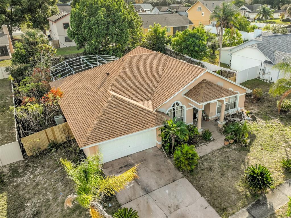 An aerial view of a single-story house with a tan roof, garage, and screened-in patio — 6832 GOLDENEYE DRIVE, ORLANDO, FL
