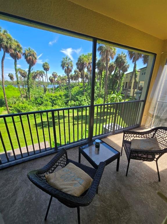 A three-story yellow stucco townhouse with a single-car garage and a concrete driveway — 4640 WILLET COOPER COURT, TAMPA, FL