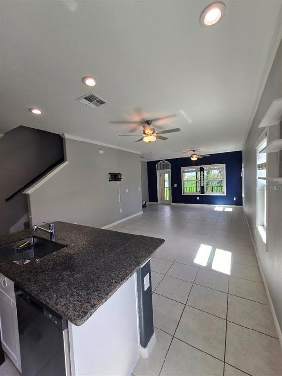 A screened-in balcony features two wicker chairs, a small glass table, and a tropical view — 4640 WILLET COOPER COURT, TAMPA, FL