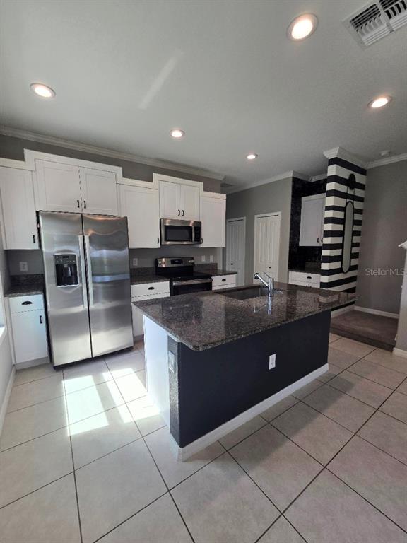A living room features light tile flooring, gray and navy walls, and two ceiling fans — 4640 WILLET COOPER COURT, TAMPA, FL