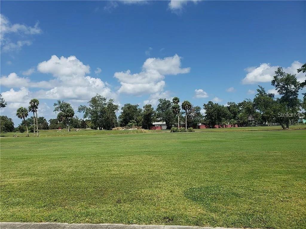A wide, grassy field stretches toward a line of trees under a blue sky — 819 GOLF AND SEA BOULEVARD, APOLLO BEACH, FL