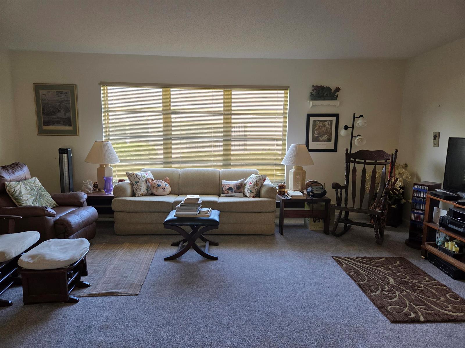 A living room features a beige sofa, a brown leather recliner, and a wooden rocking chair — 5042 Lakefront Boulevard # A, Delray Beach FL 33484, DELRAY BEACH, FL