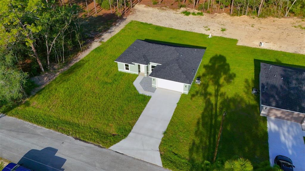 An aerial view shows a single-story house with a dark roof and concrete driveway — 6022 SW 206TH AVENUE, DUNNELLON, FL