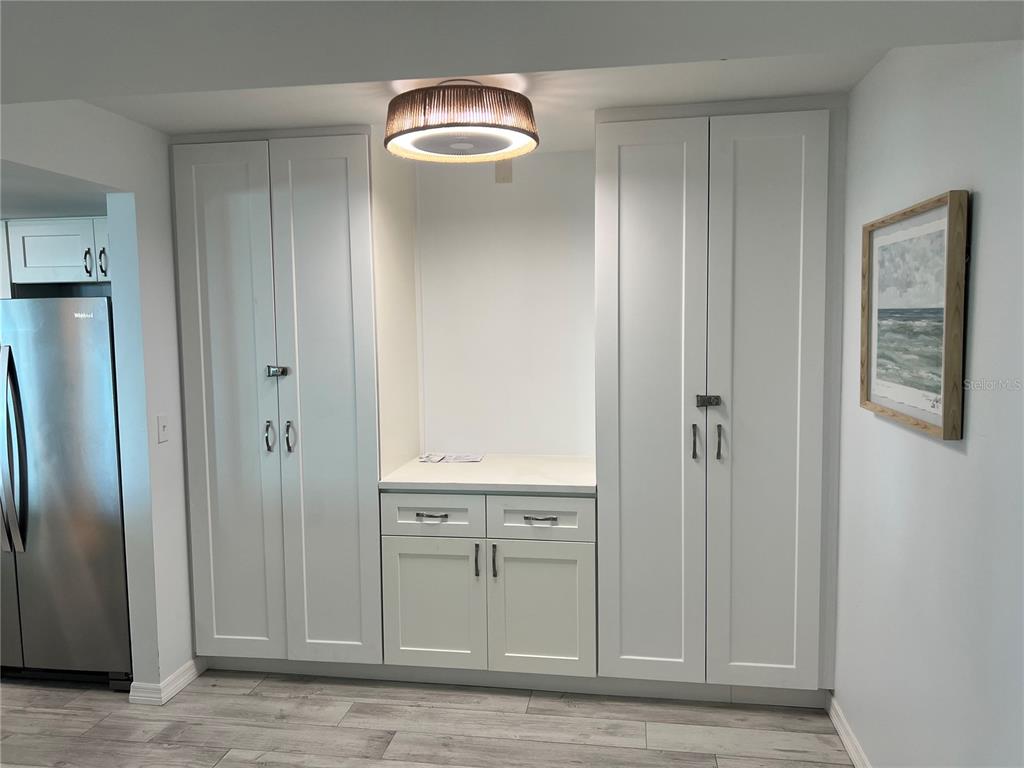 A white built-in cabinetry unit with a central countertop sits against a light gray wall — 1001 POINT OF ROCKS ROAD UNIT 611, SARASOTA, FL