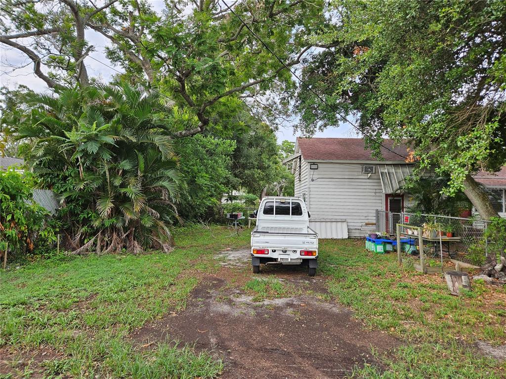 A white pickup truck is parked on a dirt driveway in front of a house — 4605 8TH AVENUE N, ST PETERSBURG, FL