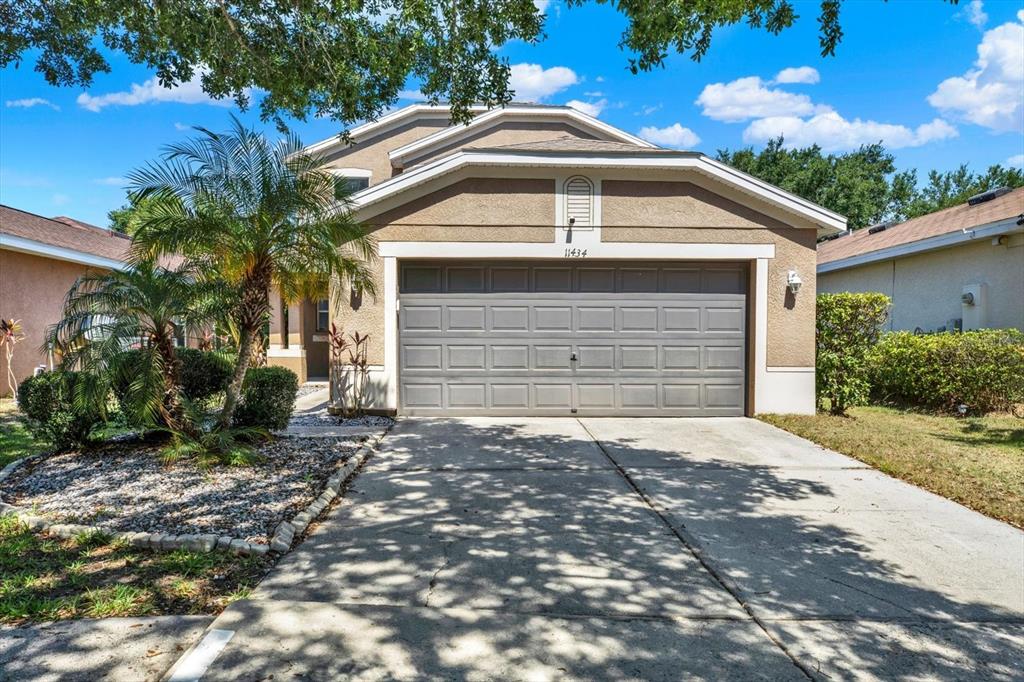 A two-story house with a beige stucco exterior and a two-car garage — 11434 CRESTLAKE VILLAGE DRIVE, RIVERVIEW, FL