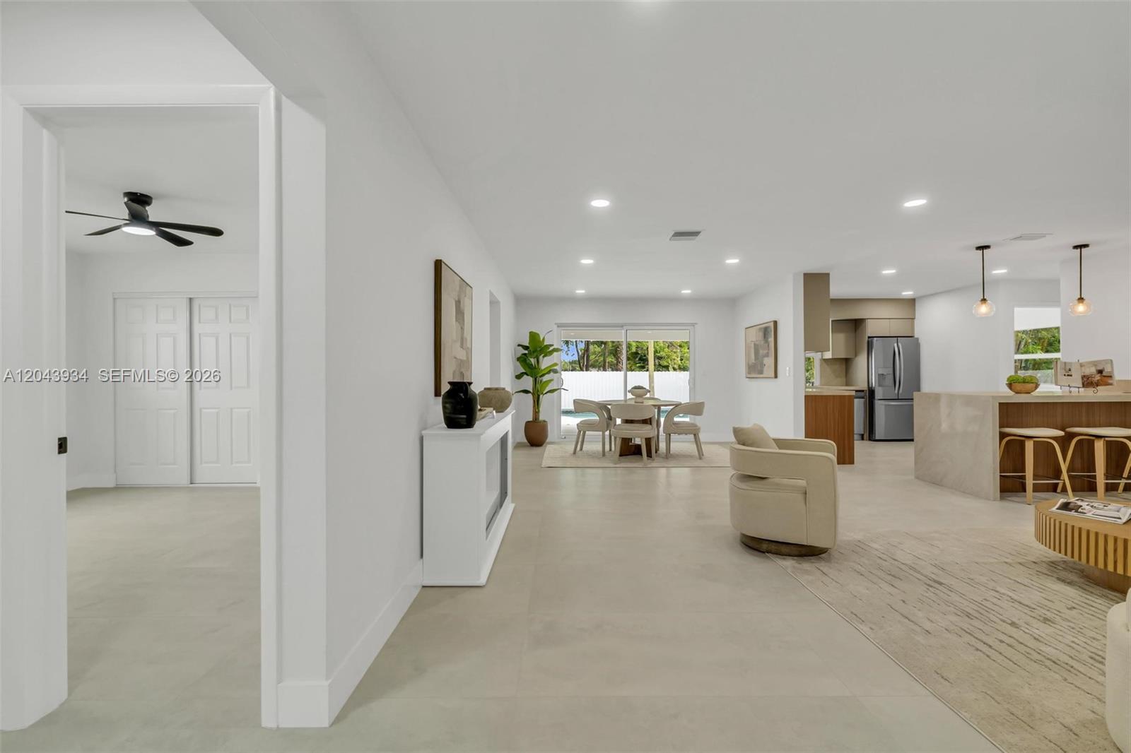 An open-concept living and dining area features light tile floors and a modern kitchen — 8970 SW 53rd St, Cooper City FL 33328, COOPER CITY, FL