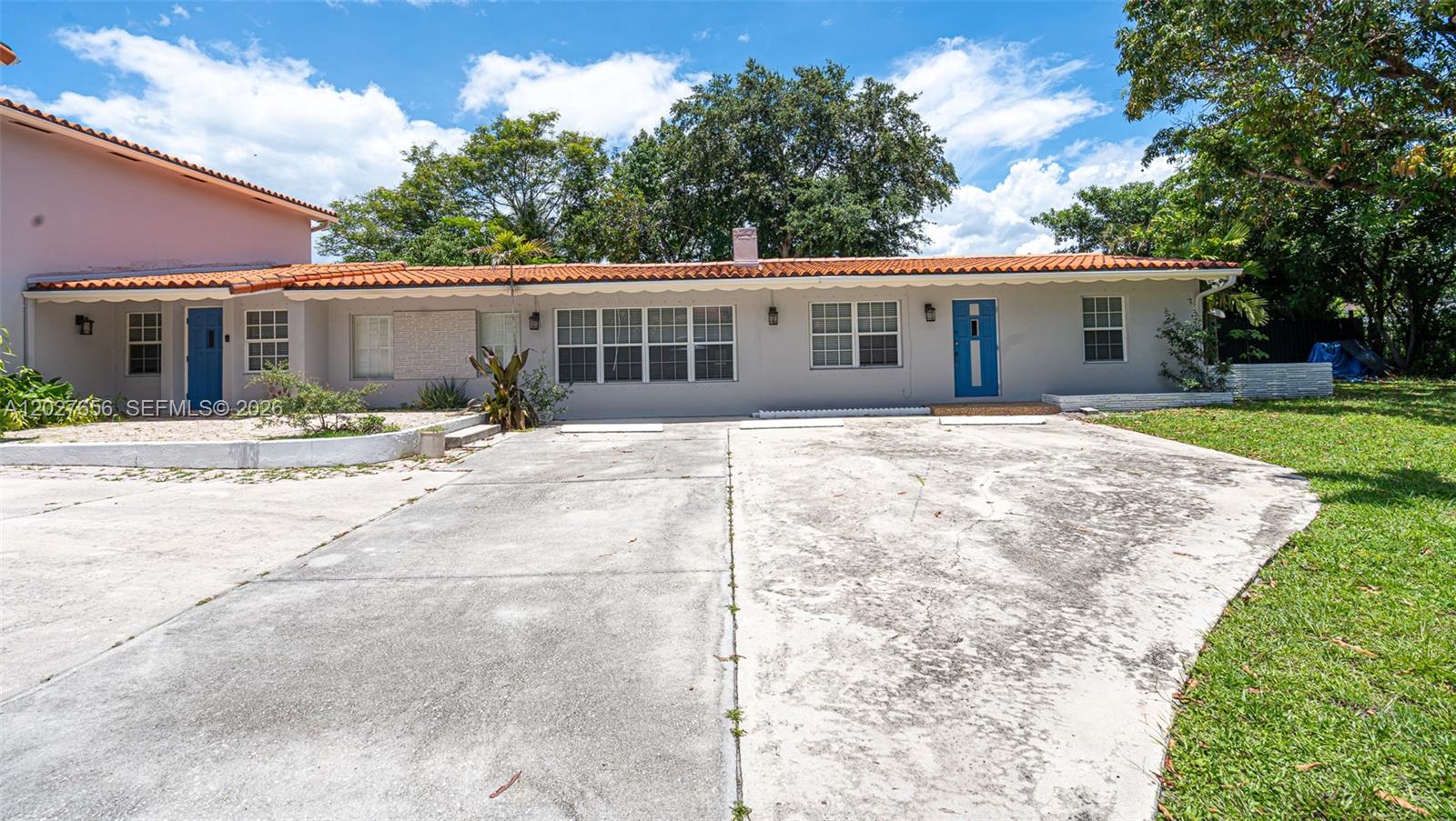 A single-story house with a concrete driveway, terracotta roof, and two blue front doors — 5613 Pierce St # 2, Hollywood FL 33021, HOLLYWOOD, FL