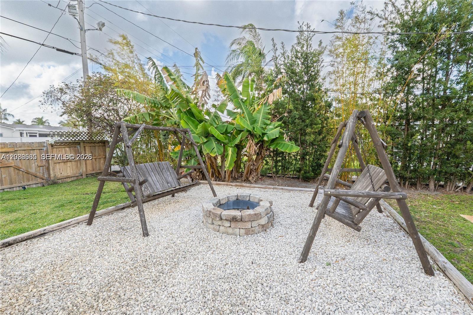 A covered outdoor kitchen with a grill overlooks a backyard swimming pool and patio — 1304 N 40th Ave, Hollywood FL 33021, HOLLYWOOD, FL
