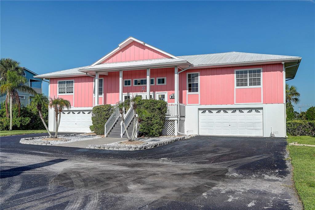 A two-story pink house with a metal roof and two white garage doors — 3263 SHOAL LINE BOULEVARD, HERNANDO BEACH, FL