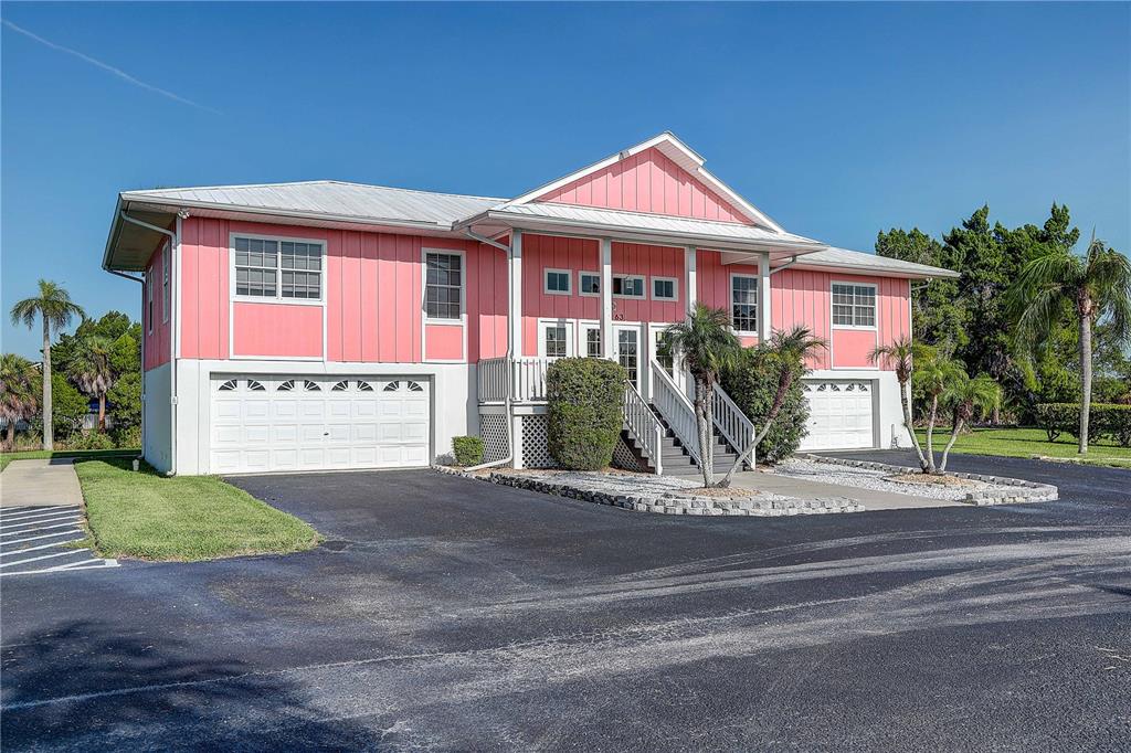 A two-story pink house with a white metal roof and two attached garages — 3263 SHOAL LINE BOULEVARD, HERNANDO BEACH, FL