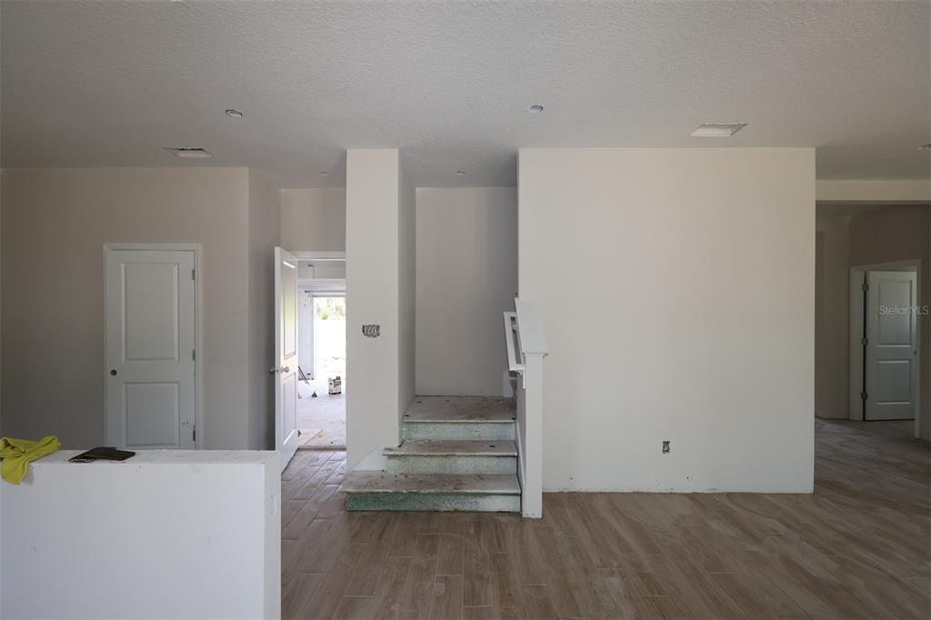 A kitchen features white cabinets, a central island, stainless steel appliances, and light-colored countertops — 6729 YELLOW WARBLER BEND, ST CLOUD, FL