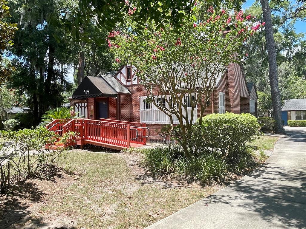 A brick building with a red wheelchair ramp and a black awning over the entrance — 914 NW 13TH STREET, GAINESVILLE, FL