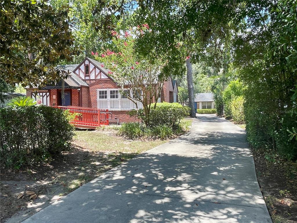 A brick house with a red wheelchair ramp and a long concrete driveway — 914 NW 13TH STREET, GAINESVILLE, FL