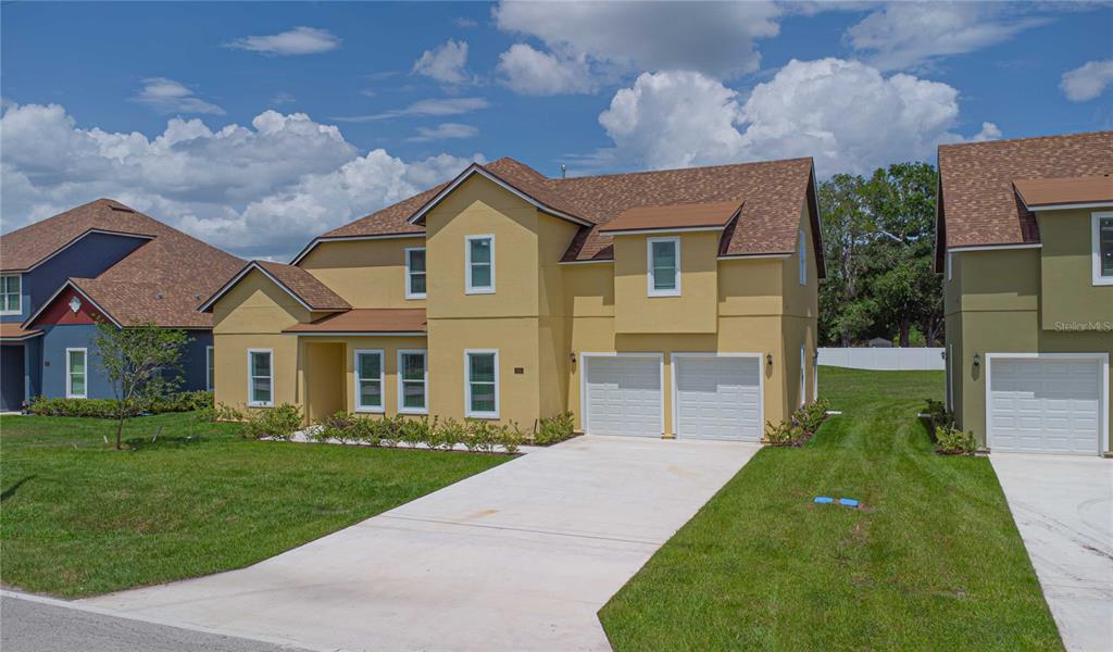 A two-story yellow house with a two-car garage and a concrete driveway — 1919 SIPES AVENUE, SANFORD, FL