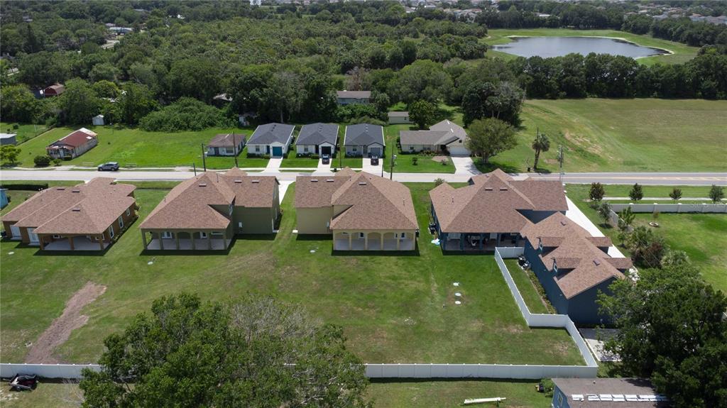 An aerial view shows several suburban houses with brown roofs and large grassy backyards — 1919 SIPES AVENUE, SANFORD, FL