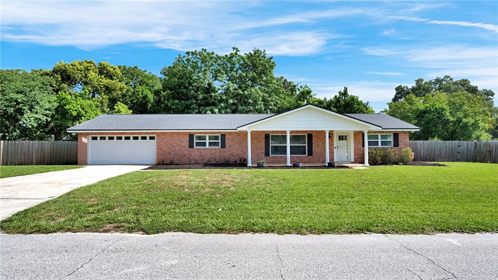 A single-story brick house with a white garage door, front porch, and a large lawn — 1179 FOREST HILLS ROAD, ALTAMONTE SPRINGS, FL