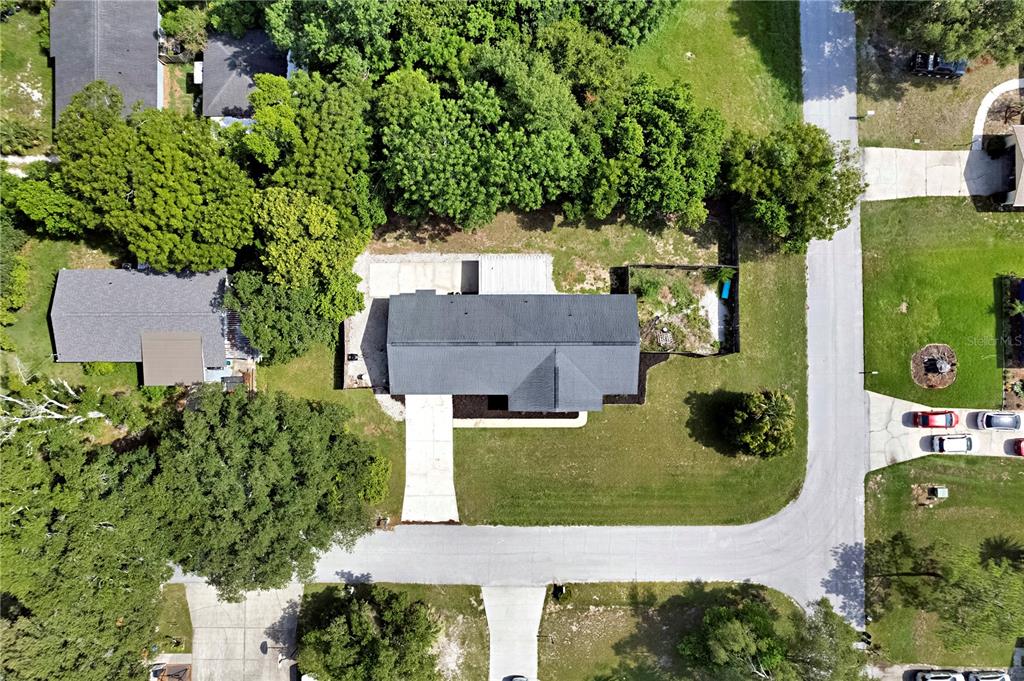 An aerial view shows a single-story house with a dark roof, driveway, and surrounding trees — 1179 FOREST HILLS ROAD, ALTAMONTE SPRINGS, FL