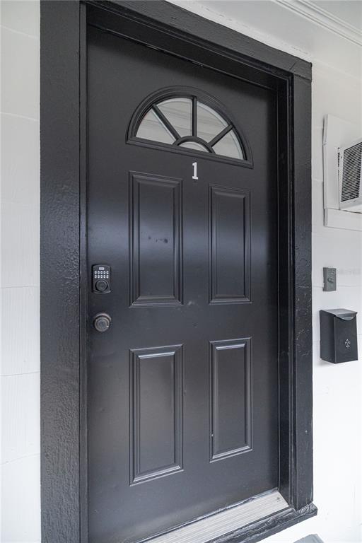 A black front door with a small arched window and a digital keypad lock — 917 30TH AVENUE N UNIT 1, ST PETERSBURG, FL