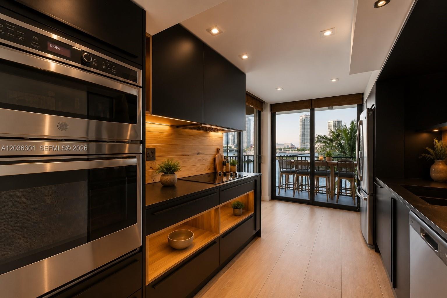 A modern kitchen features black cabinetry, wood shelving, stainless steel appliances, and a balcony view — 801 N Venetian Dr # 308, Miami FL 33139, MIAMI, FL
