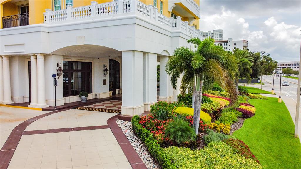 The exterior entrance of a building features white columns, a tiled walkway, and landscaped gardens — 345 BAYSHORE BOULEVARD UNIT P9, TAMPA, FL