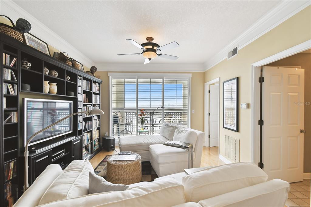 A living room features a large black entertainment center, white sectional sofas, and a ceiling fan — 345 BAYSHORE BOULEVARD UNIT P9, TAMPA, FL