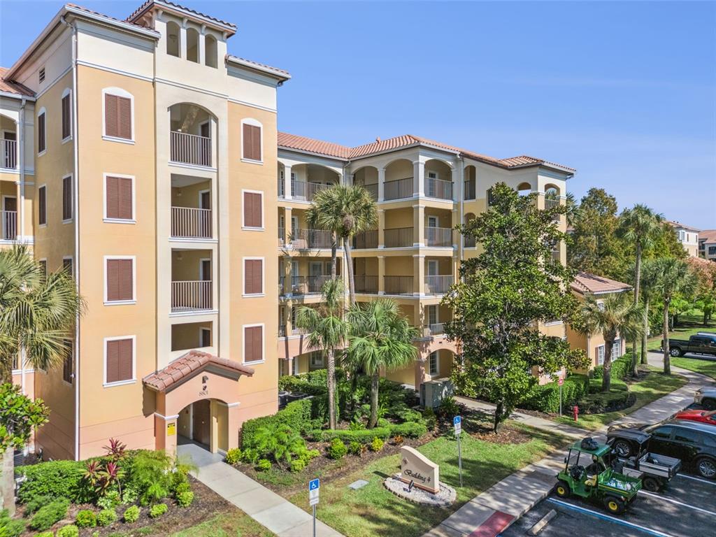 An exterior view of a multi-story apartment building with balconies and a parking lot — 8801 WORLDQUEST BOULEVARD UNIT 4108, ORLANDO, FL