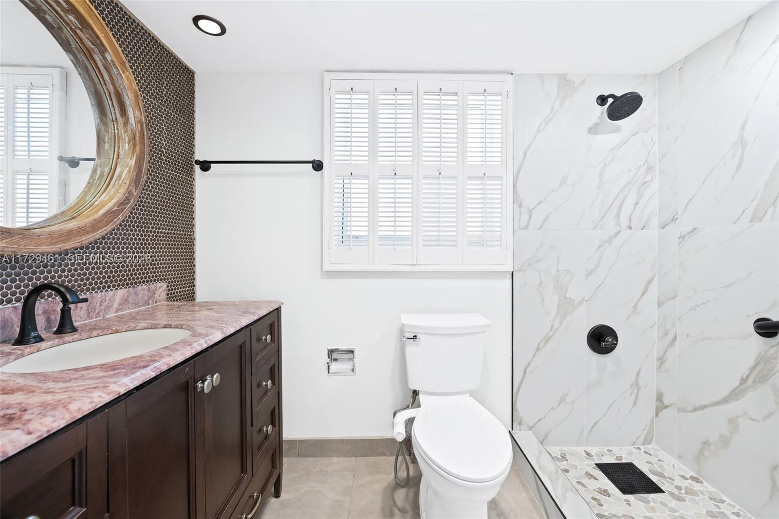 A bathroom features a dark wood vanity, marble countertop, toilet, and a walk-in shower — 3050 N Palm Aire Dr # 501, Pompano Beach FL 33069, POMPANO BEACH, FL