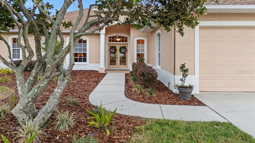 The exterior of a beige house features a paved walkway leading to double front doors — 3710 LITTLE COUNTRY ROAD, PARRISH, FL
