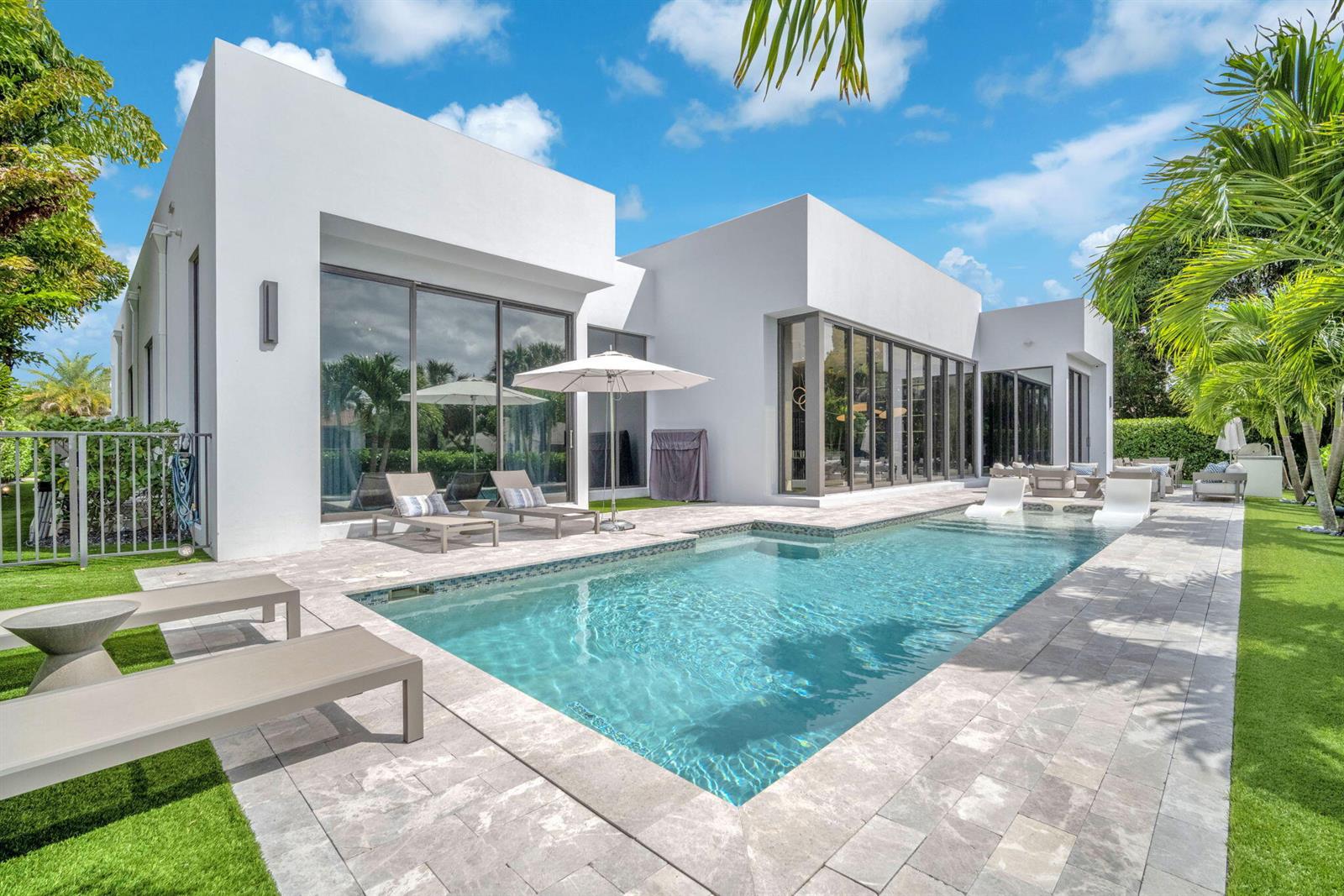 A modern white house with a swimming pool and patio area in a backyard — 17787 Scarsdale Way, Boca Raton FL 33496, BOCA RATON, FL