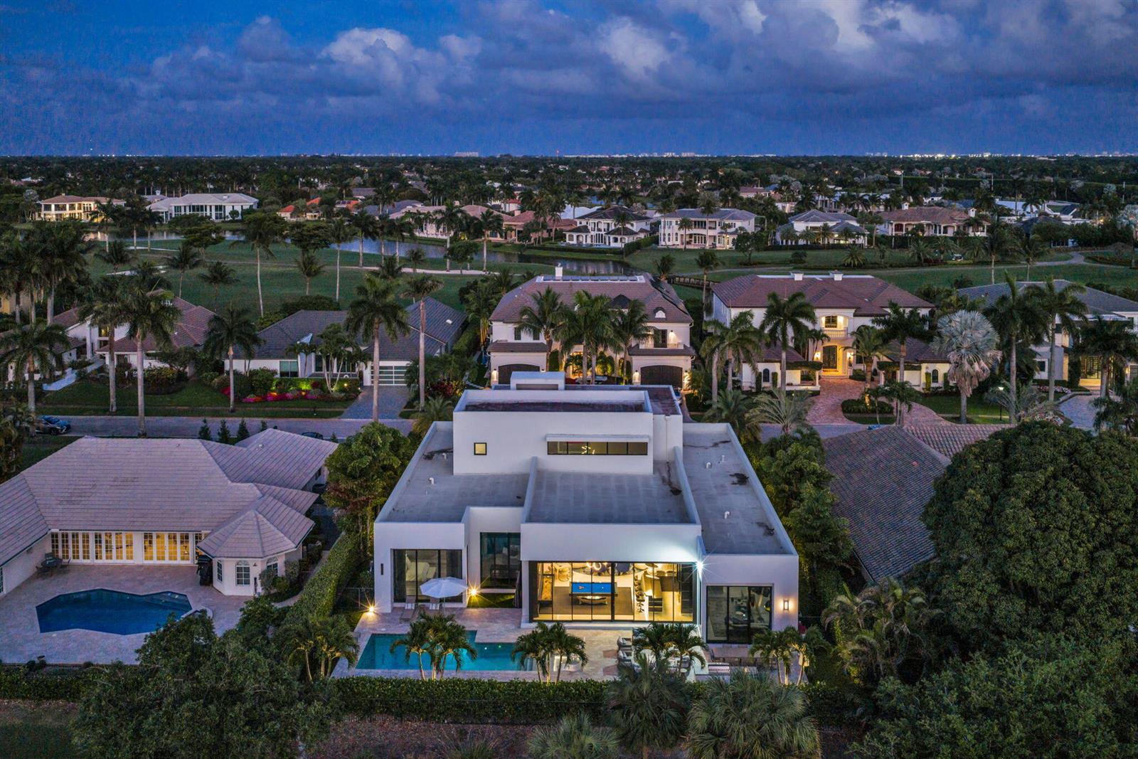 An aerial view of a modern white house with a pool at dusk — 17787 Scarsdale Way, Boca Raton FL 33496, BOCA RATON, FL