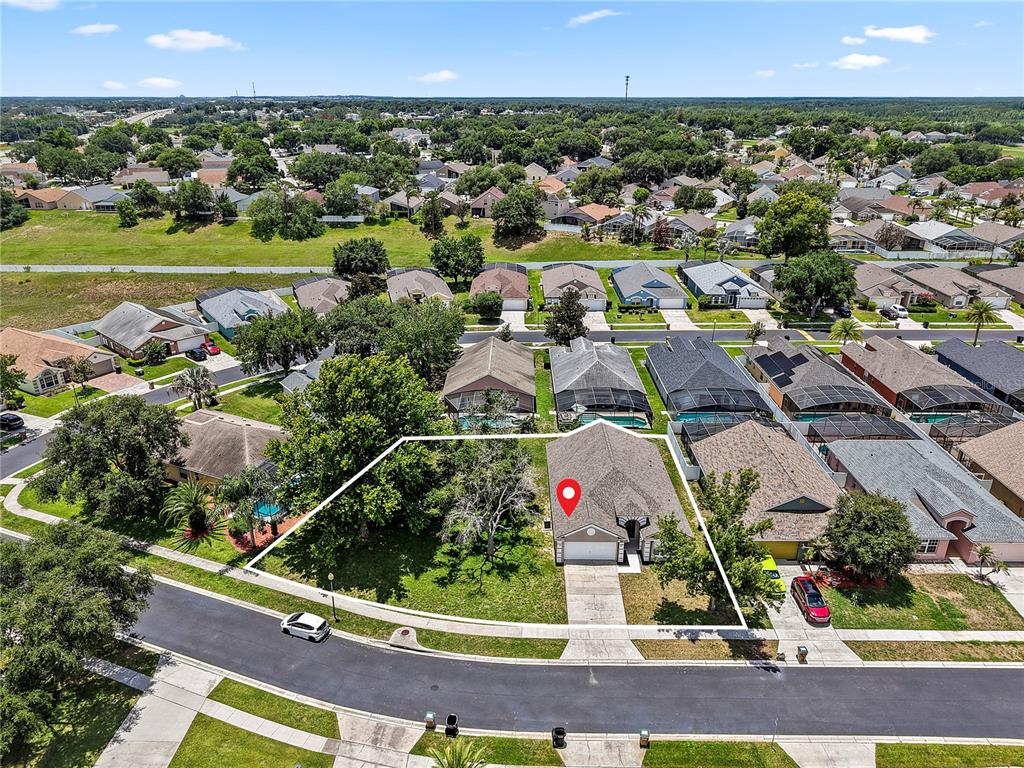 An aerial view shows a single-story house with a large yard and a white outline — 3103 MERLOT WAY, CLERMONT, FL