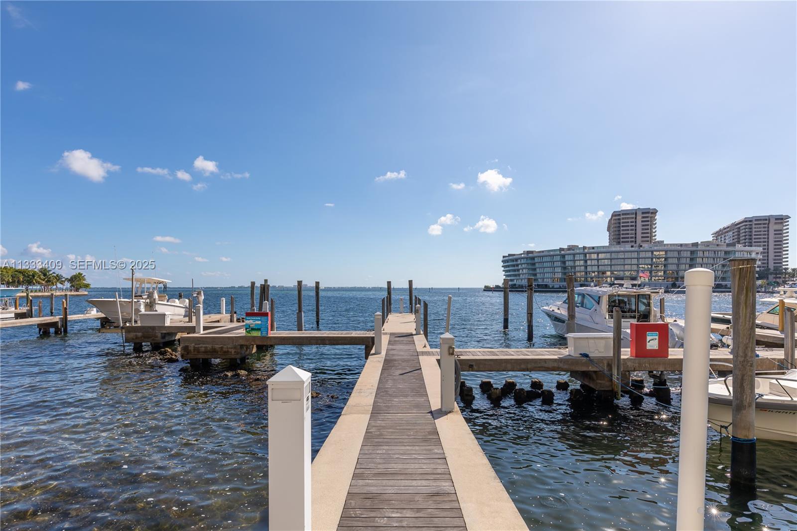 A wooden dock extends into the water with several boats moored alongside — 1660 W Glencoe St # 302, Coconut Grove FL 33133, COCONUT GROVE, FL
