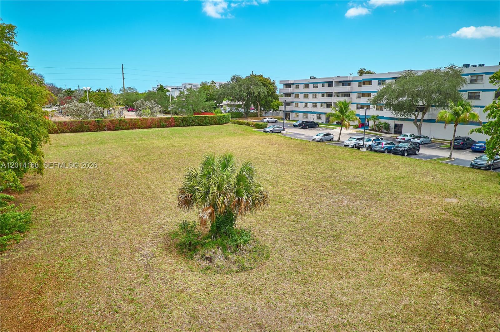 An aerial view shows a large, grassy vacant lot with a single palm tree — 0 N 61  Avenue, Hollywood FL 33024, HOLLYWOOD, FL
