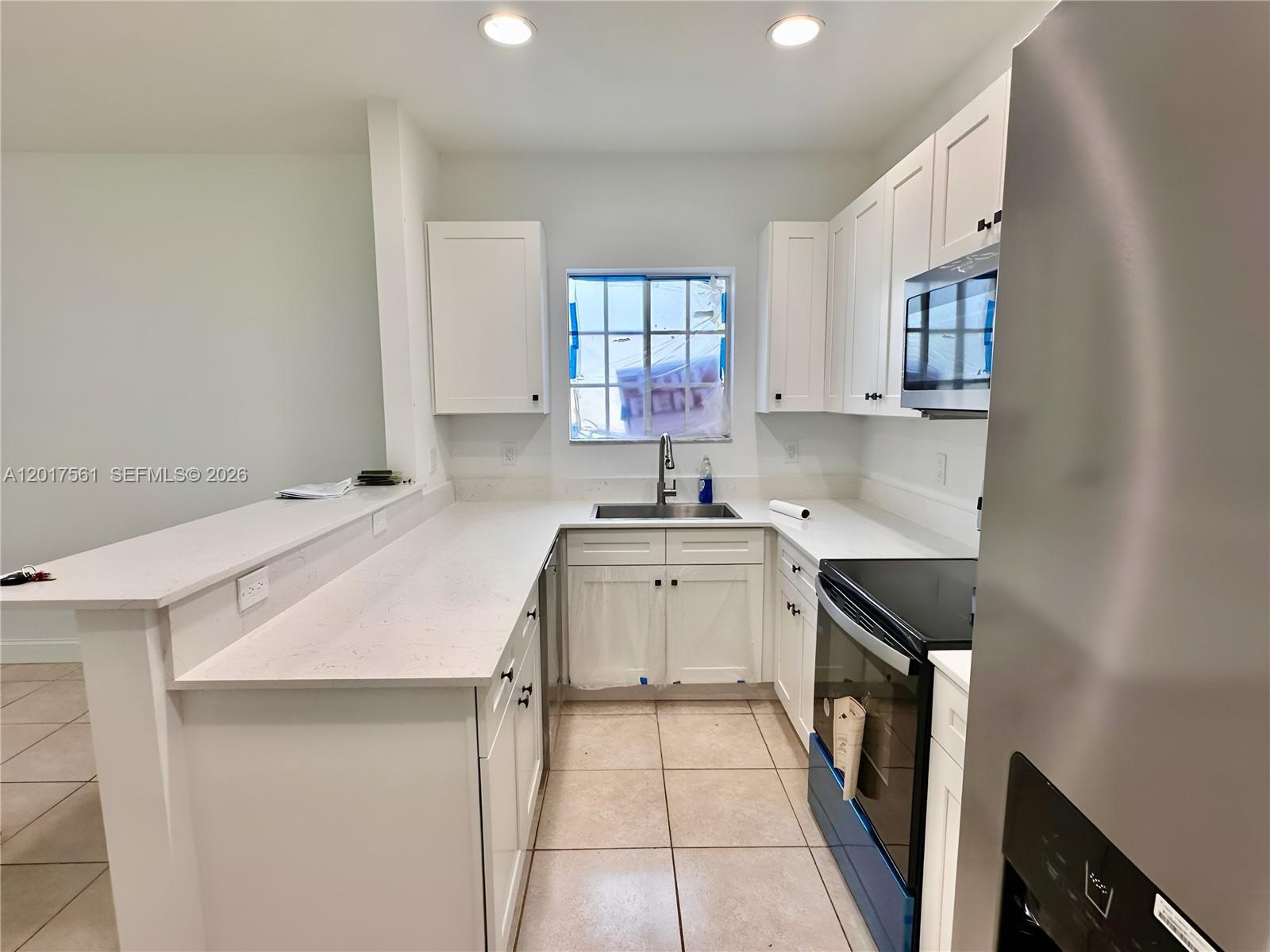 A kitchen features white cabinets, stainless steel appliances, and light-colored countertops — 2301 Wilson St # A, Hollywood FL 33020, HOLLYWOOD, FL