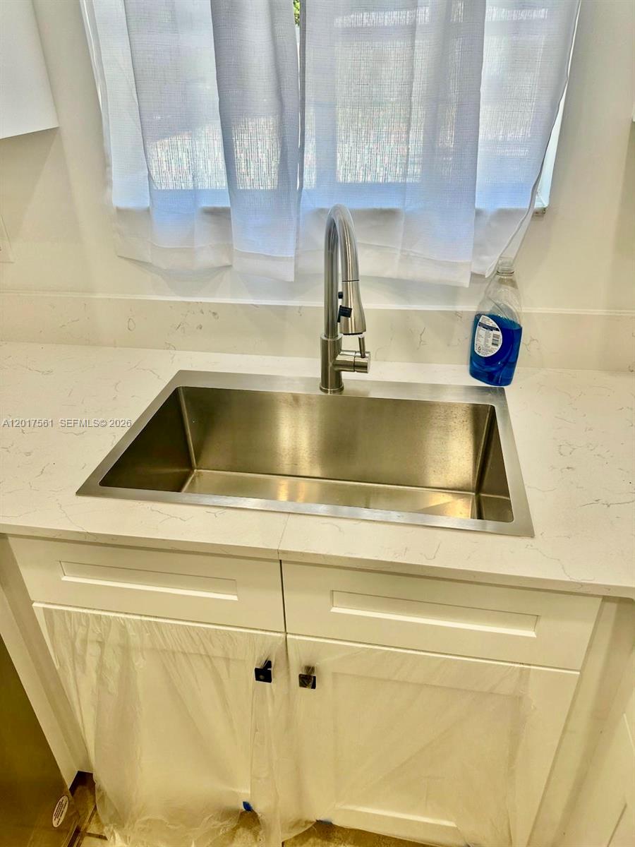 A stainless steel kitchen sink with a faucet is set into a white countertop — 2301 Wilson St # A, Hollywood FL 33020, HOLLYWOOD, FL