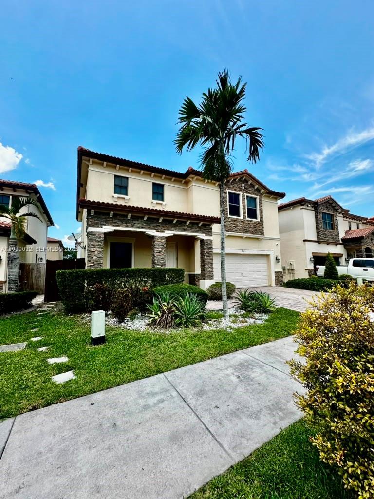 A two-story suburban house with a stone facade, a palm tree, and a concrete driveway — 9825 NW 86th Ter, Doral FL 33178, DORAL, FL