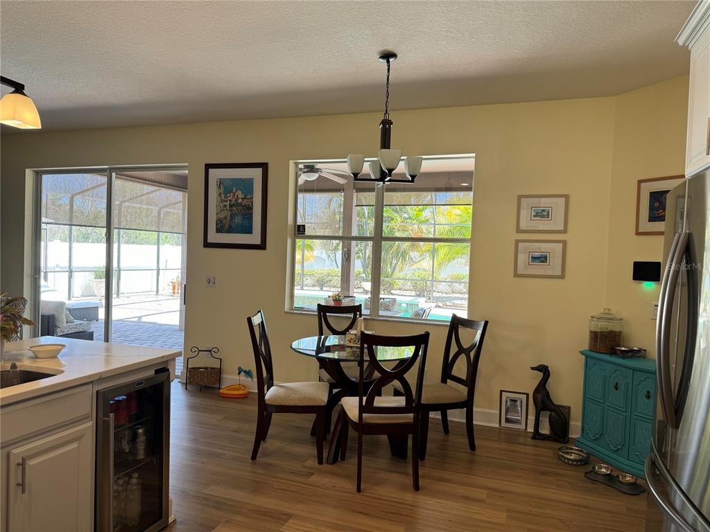 A dining area with a glass table, four chairs, and a view of a pool — 2127 BRISTOL GRANDE WAY, ORLANDO, FL